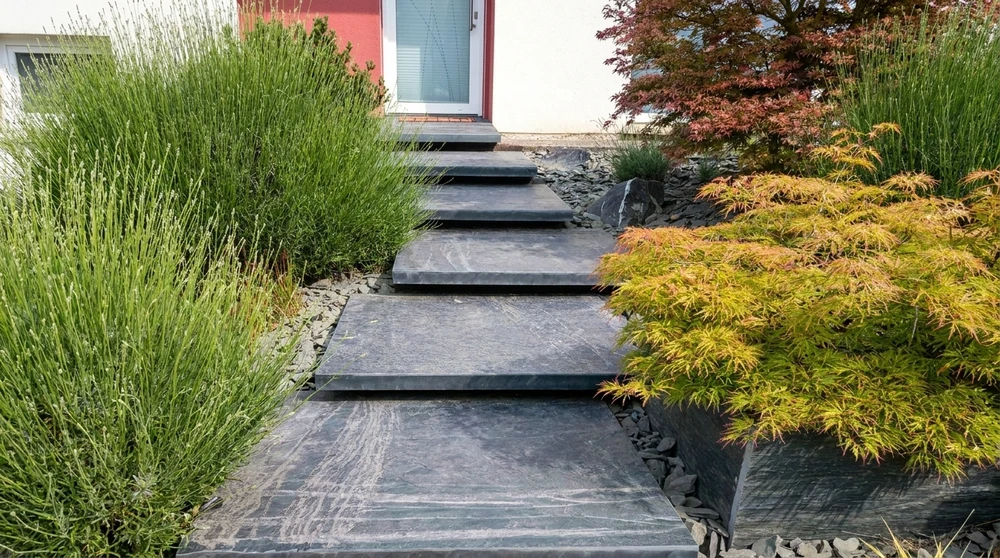 Escalier extérieur d'entrée de maison contemporaine, composé de larges marches en pierre naturelle ardoise bleue-grise, finition brossée, veinures apparentes