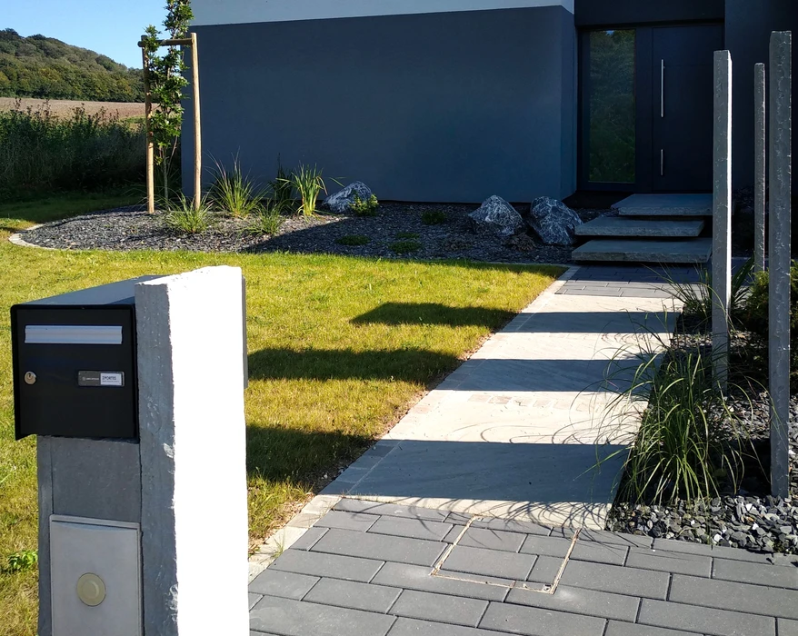 Entrée de maison contemporaine avec allée en dalles de calcaire beige et ardoise anthracite