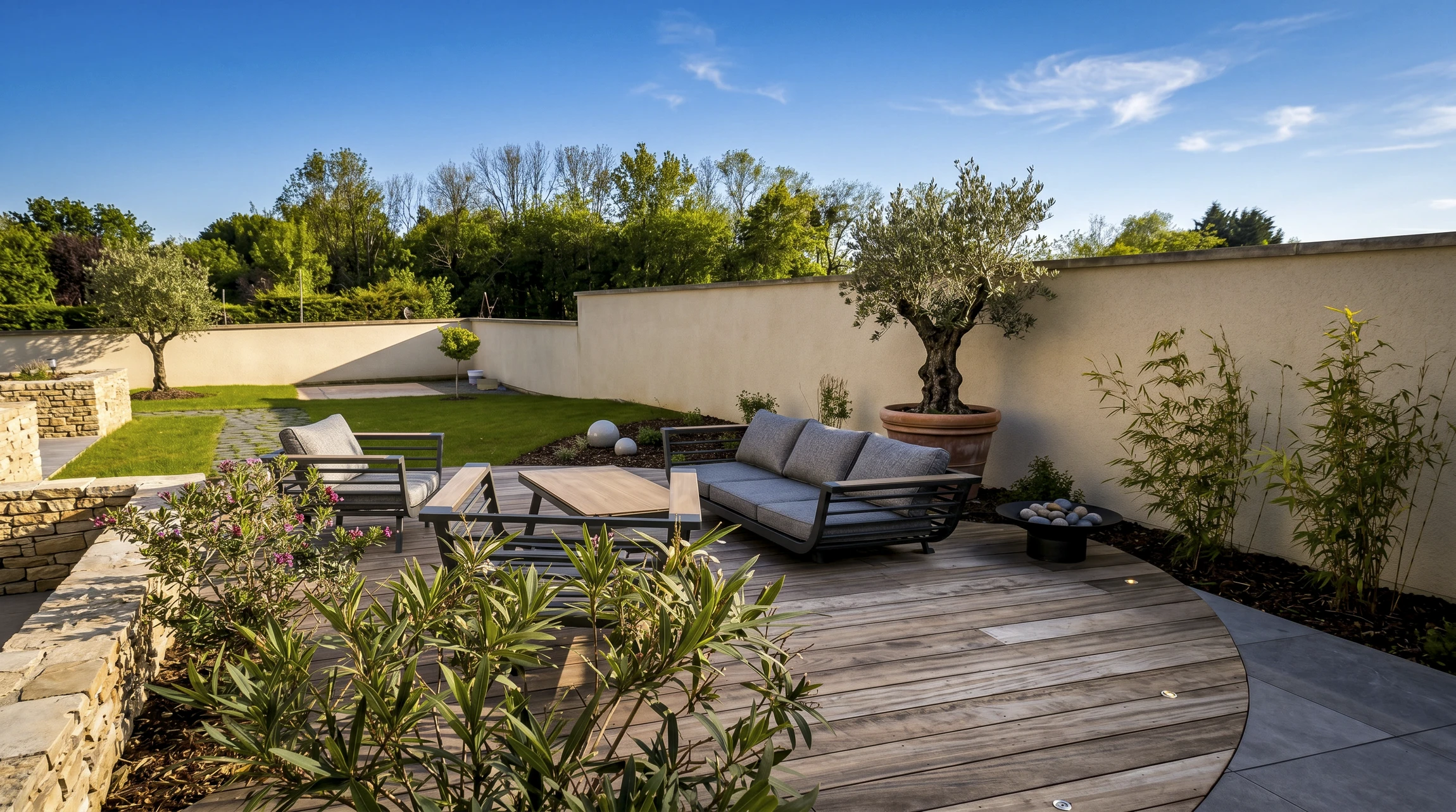 Terrasse en bois composite avec salon de jardin en fer forgé noir dans jardin paysager